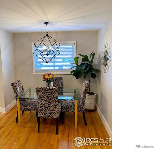 7170 Zuni St, Denver, CO 80221 - dining space featuring light wood finished floors, a notable chandelier, and baseboards