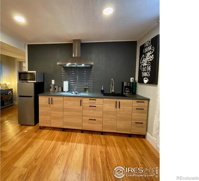 7170 Zuni St, Denver, CO 80221 - kitchen featuring light wood-style flooring, a sink, wall chimney range hood, and stainless steel appliances