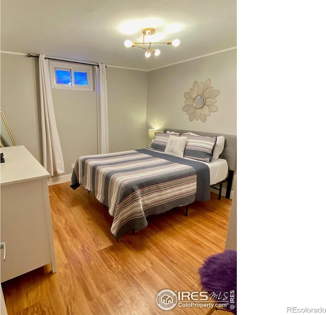 7170 Zuni St, Denver, CO 80221 - bedroom featuring light wood-type flooring and an inviting chandelier