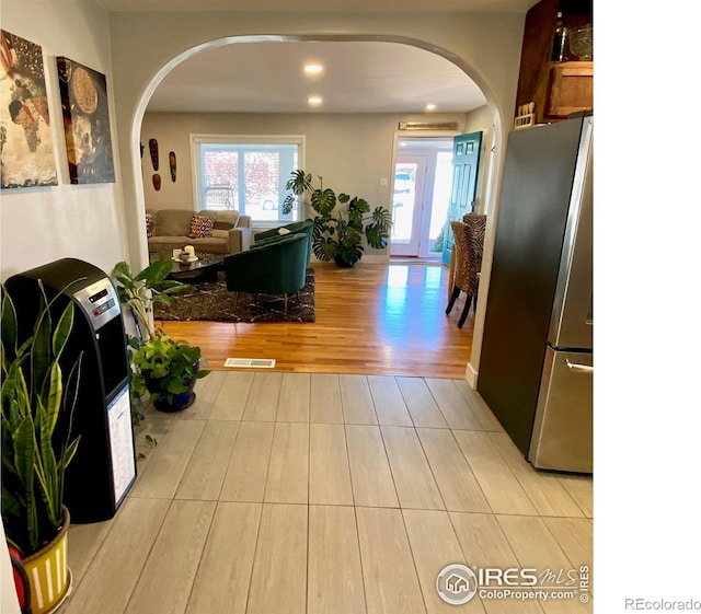 7170 Zuni St, Denver, CO 80221 - hall with arched walkways, recessed lighting, visible vents, and light wood-style floors