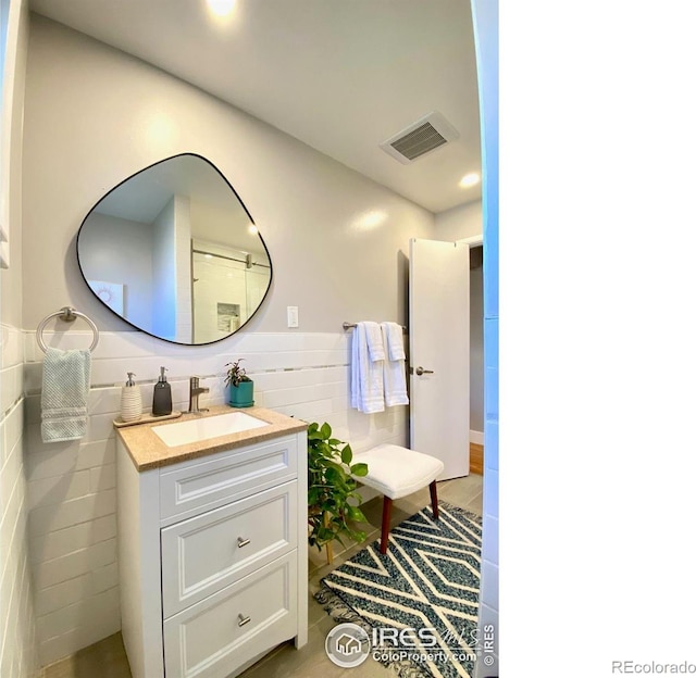 7170 Zuni St, Denver, CO 80221 - bathroom with vanity, recessed lighting, visible vents, and tile walls