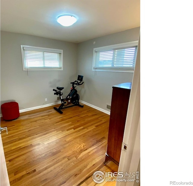 7170 Zuni St, Denver, CO 80221 - workout area with visible vents, baseboards, light wood finished floors, and plenty of natural light