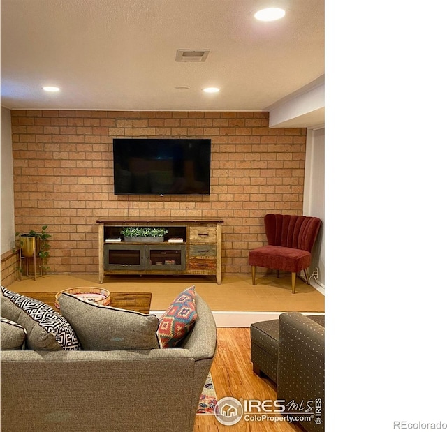 7170 Zuni St, Denver, CO 80221 - living room with brick wall, recessed lighting, visible vents, and wood finished floors
