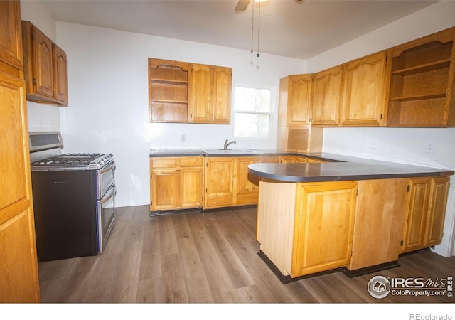 kitchen with open shelves, a sink, dark wood-style flooring, a peninsula, and range with two ovens