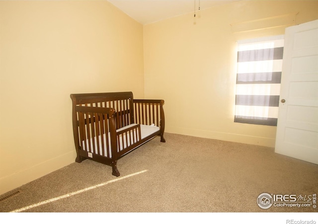 bedroom featuring carpet floors and a crib