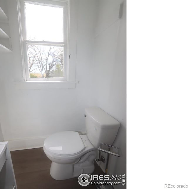bathroom with toilet, wood finished floors, and baseboards