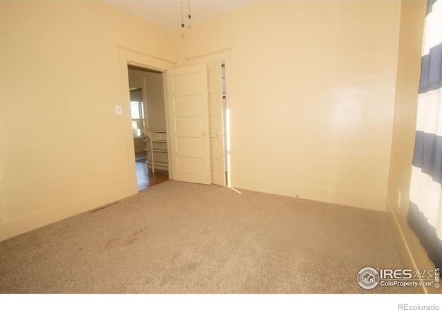 carpeted empty room featuring baseboards