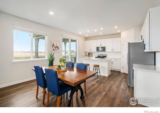 dining area with dark wood-style flooring, baseboards, and recessed lighting