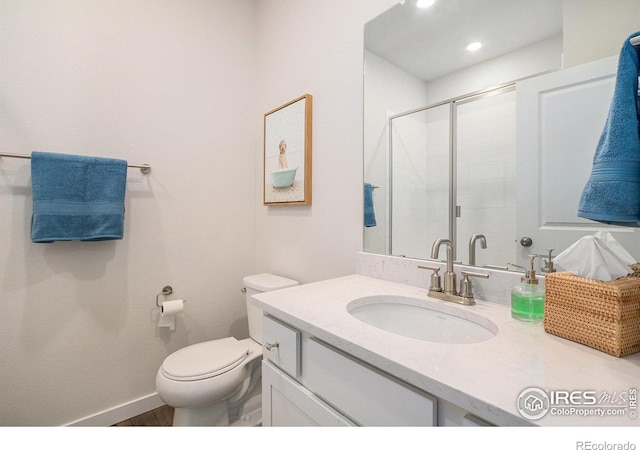 bathroom with toilet, wood finished floors, vanity, recessed lighting, and a shower stall