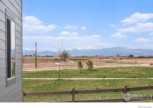 view of yard with fence, a rural view, and a mountain view
