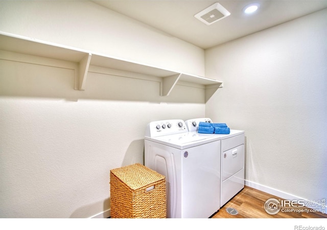 laundry area featuring laundry area, baseboards, visible vents, light wood-style floors, and separate washer and dryer