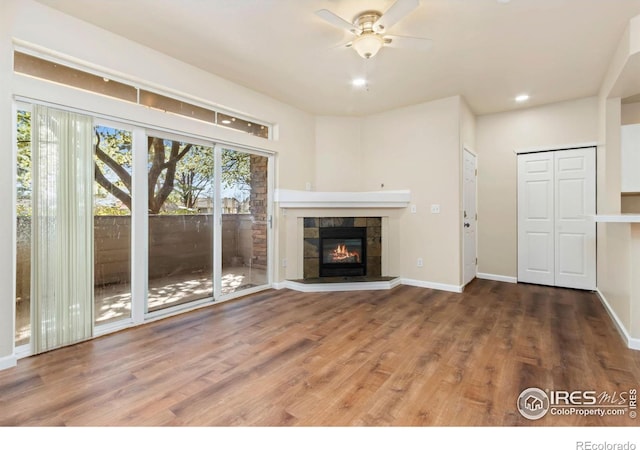 unfurnished living room featuring ceiling fan, recessed lighting, wood finished floors, and a fireplace