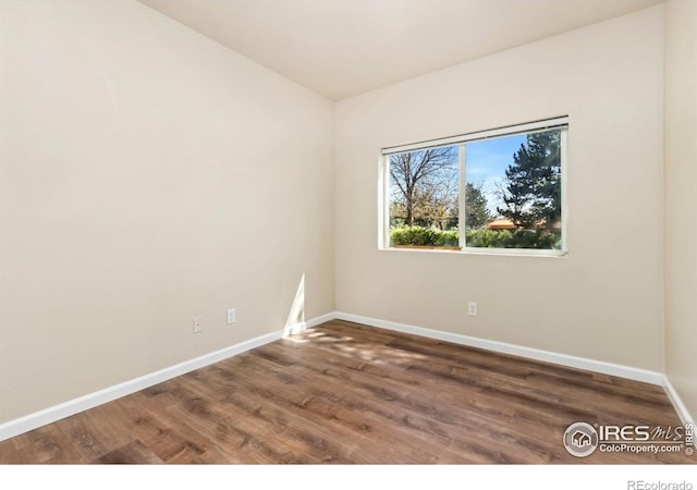 unfurnished room with baseboards and wood finished floors