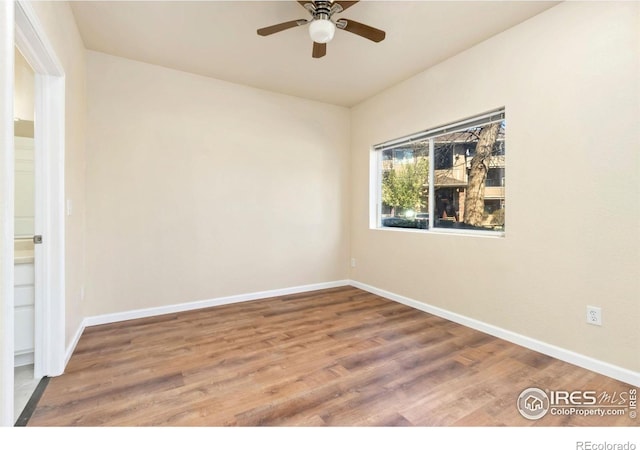 unfurnished room with ceiling fan, wood finished floors, and baseboards