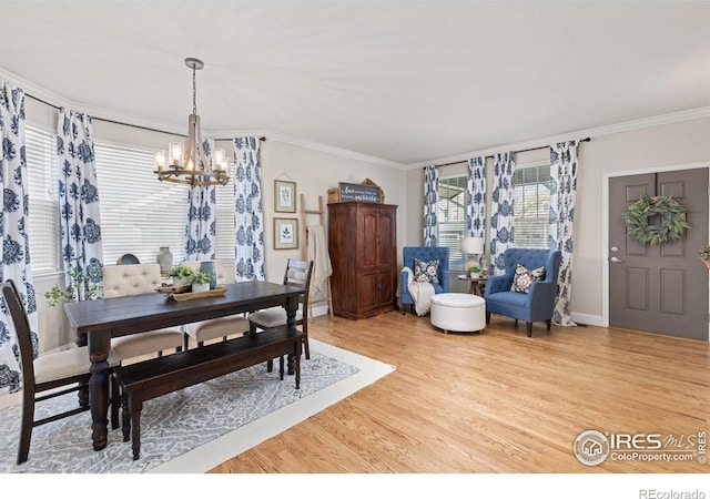 248 Muscovey Ln, Johnstown, CO 80534 - dining space featuring light wood-style floors, a notable chandelier, ornamental molding, and baseboards