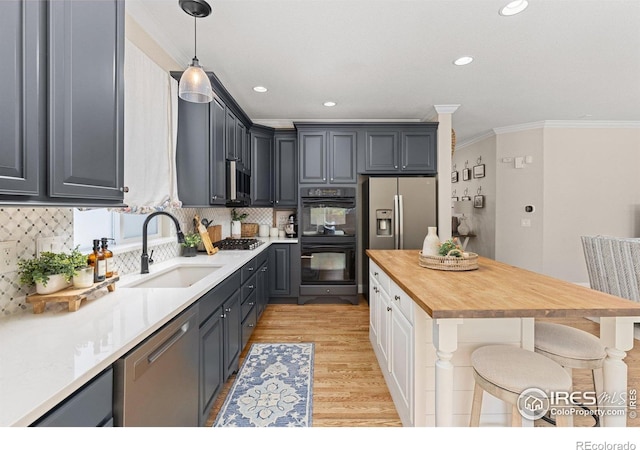 248 Muscovey Ln, Johnstown, CO 80534 - kitchen featuring a sink, ornamental molding, a breakfast bar, stainless steel appliances, and light wood-style flooring
