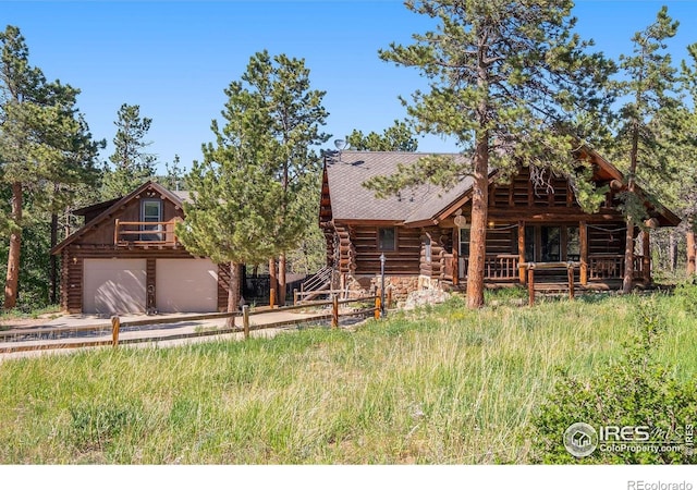 212 Valley Rd, Lyons, CO 80540 - log home featuring concrete driveway, log siding, roof with shingles, and an attached garage