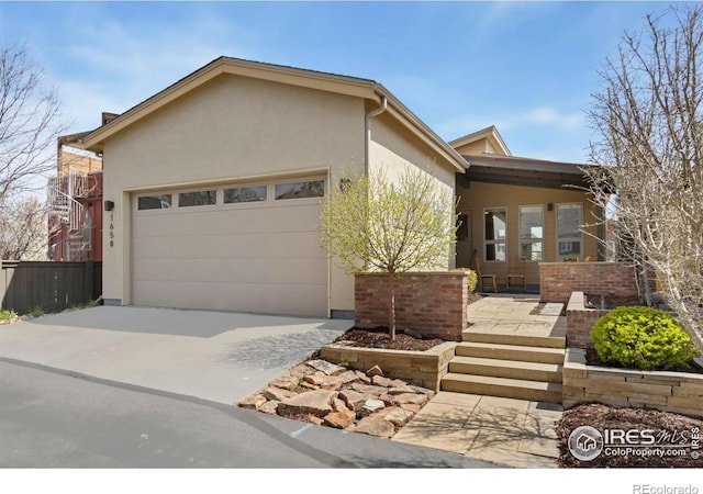 1658 Freewheel Dr, Fort Collins, CO 80525 - view of front of property featuring concrete driveway, stucco siding, fence, and an attached garage