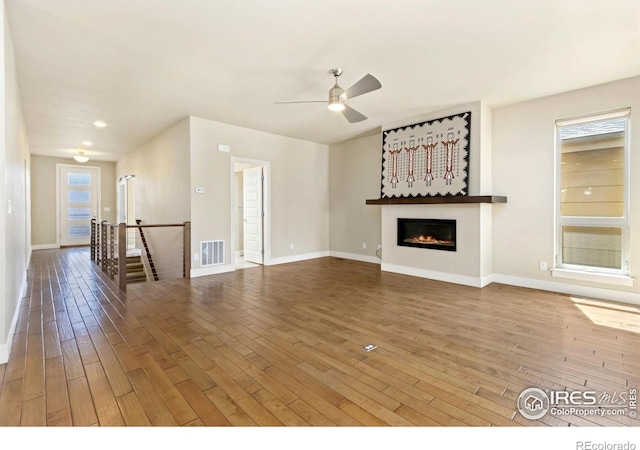 1658 Freewheel Dr, Fort Collins, CO 80525 - unfurnished living room with visible vents, baseboards, ceiling fan, hardwood / wood-style floors, and a glass covered fireplace