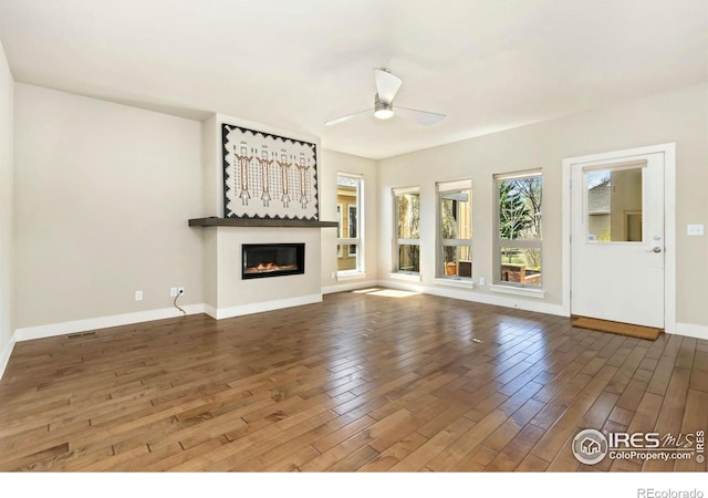 1658 Freewheel Dr, Fort Collins, CO 80525 - unfurnished living room with a glass covered fireplace, ceiling fan, baseboards, and wood finished floors