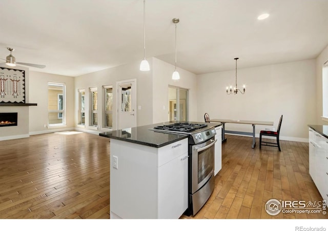 1658 Freewheel Dr, Fort Collins, CO 80525 - kitchen featuring light wood finished floors, pendant lighting, stainless steel range with gas stovetop, and dark countertops