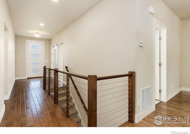 1658 Freewheel Dr, Fort Collins, CO 80525 - hall featuring visible vents, baseboards, wood-type flooring, and a barn door
