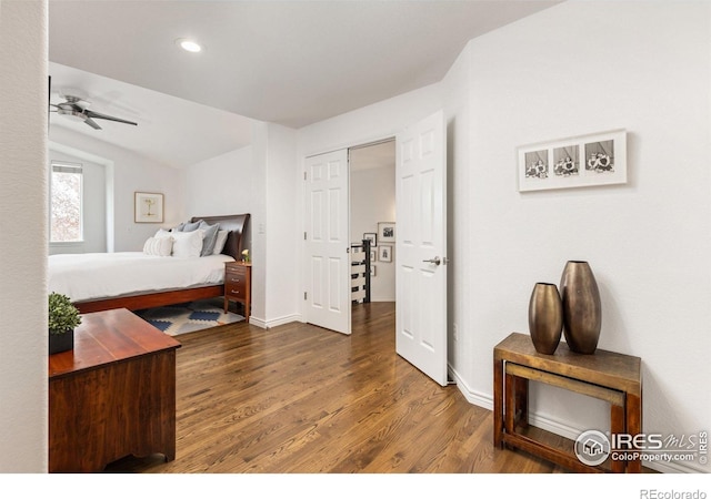 bedroom with baseboards, vaulted ceiling, and wood finished floors