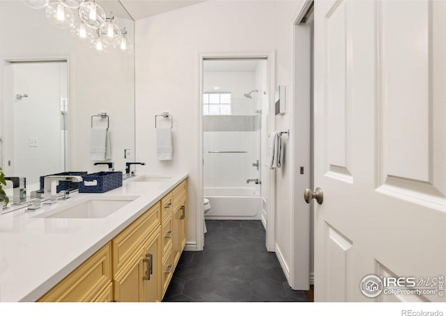 bathroom with double vanity, shower / bathtub combination, a sink, and toilet