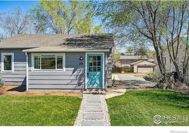 285 Holbrook St, Erie, CO 80516 - view of front of home featuring a front yard, roof with shingles, fence, and an outbuilding