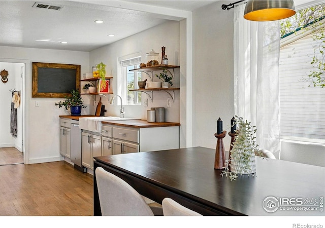 285 Holbrook St, Erie, CO 80516 - kitchen featuring butcher block countertops, open shelves, visible vents, light wood finished floors, and a sink