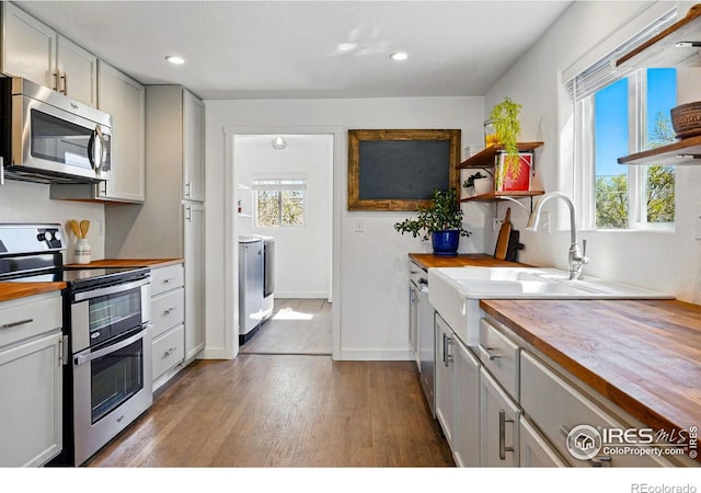 285 Holbrook St, Erie, CO 80516 - kitchen featuring recessed lighting, open shelves, butcher block counters, dark wood-type flooring, and appliances with stainless steel finishes