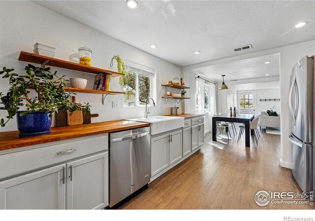 285 Holbrook St, Erie, CO 80516 - kitchen with visible vents, open shelves, a sink, butcher block counters, and stainless steel appliances