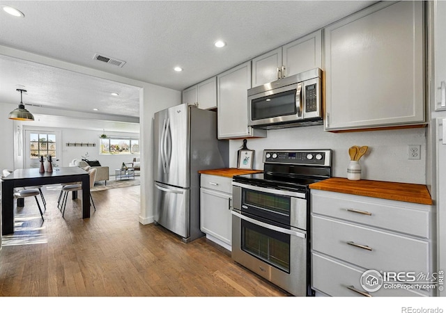 285 Holbrook St, Erie, CO 80516 - kitchen featuring dark wood-type flooring, butcher block counters, visible vents, recessed lighting, and stainless steel appliances