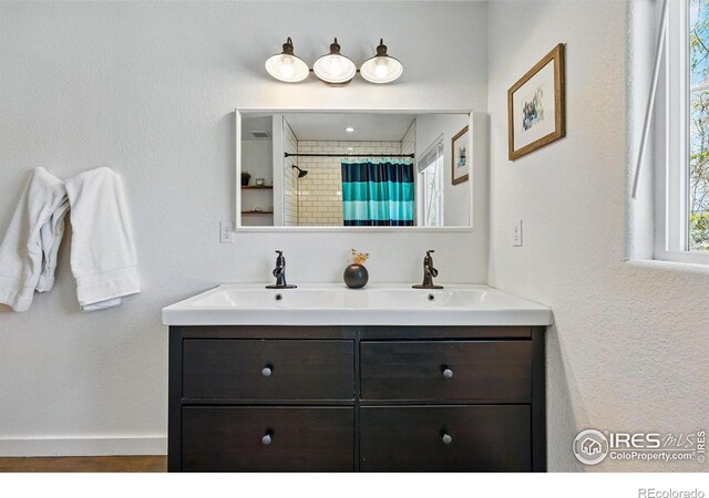 285 Holbrook St, Erie, CO 80516 - bathroom featuring a shower with shower curtain, double vanity, baseboards, and a sink