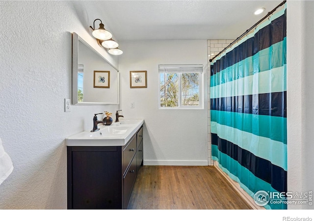 285 Holbrook St, Erie, CO 80516 - full bathroom with a textured wall, a shower with shower curtain, vanity, and wood finished floors