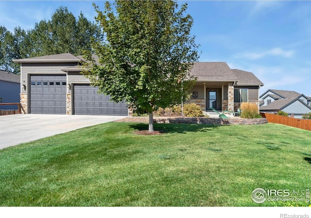 view of front of home with a front yard, an attached garage, stone siding, fence, and concrete driveway