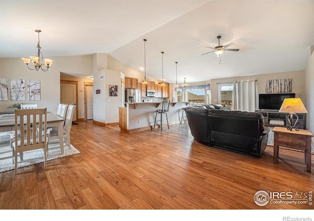 living room featuring light wood-type flooring, ceiling fan with notable chandelier, baseboards, and lofted ceiling