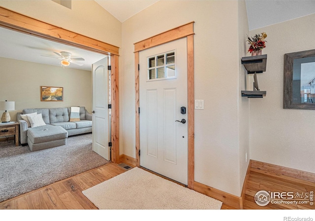 entrance foyer with baseboards, vaulted ceiling, ceiling fan, and wood finished floors