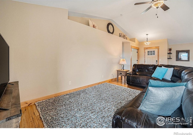 living area featuring ceiling fan, baseboards, wood finished floors, and lofted ceiling