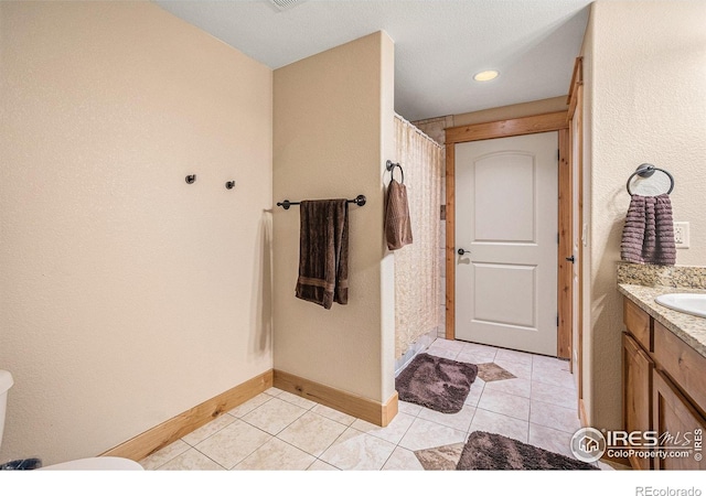 bathroom with tile patterned floors, vanity, a shower with curtain, and baseboards
