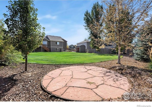 view of yard with a patio area, stairway, and fence