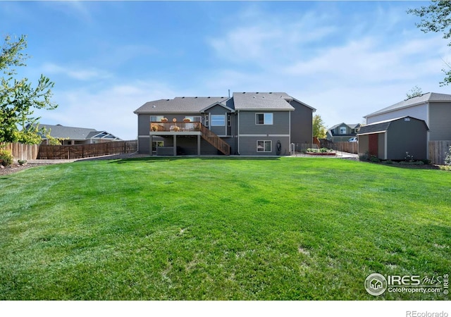 rear view of property with a storage shed, a fenced backyard, an outdoor structure, and stairway