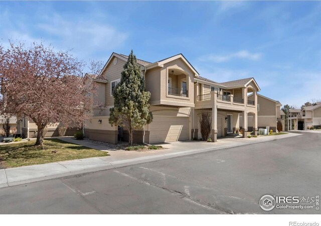 5151 Boardwalk Dr Unit K4, Fort Collins, CO 80525 - view of front of house featuring stucco siding, a garage, and a balcony