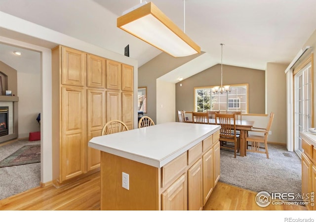 5151 Boardwalk Dr Unit K4, Fort Collins, CO 80525 - kitchen featuring a glass covered fireplace, light wood-style flooring, a kitchen island, lofted ceiling, and light brown cabinetry