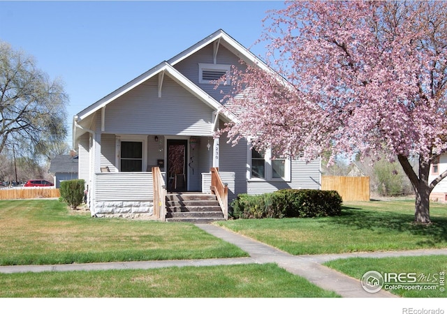 230 Beattie St, Sterling, CO 80751 - view of front of home with a porch, a front yard, and fence