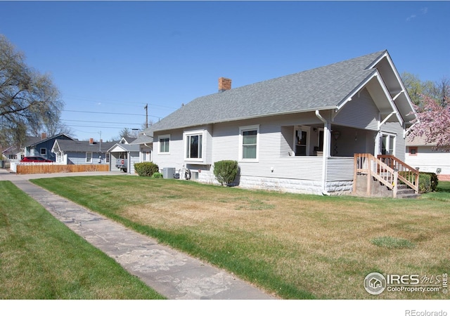 230 Beattie St, Sterling, CO 80751 - view of side of home featuring central AC, covered porch, a lawn, roof with shingles, and a chimney