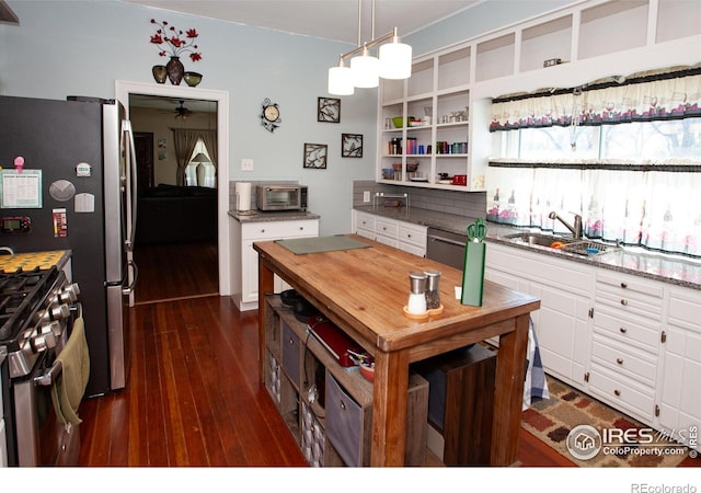 230 Beattie St, Sterling, CO 80751 - kitchen with white cabinets, a sink, dark wood-style flooring, ceiling fan, and stainless steel gas range oven