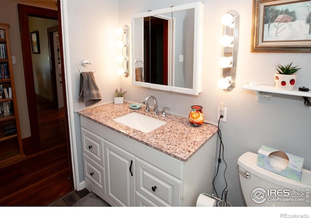 230 Beattie St, Sterling, CO 80751 - half bathroom featuring vanity, toilet, and wood finished floors