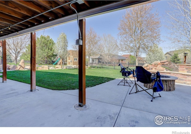 view of patio / terrace featuring an outdoor fire pit, a fenced backyard, and a playground