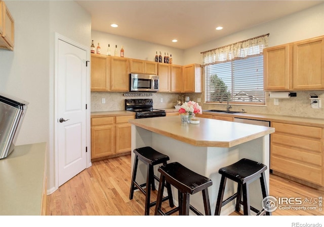 kitchen featuring a sink, black / electric stove, stainless steel microwave, and light brown cabinets